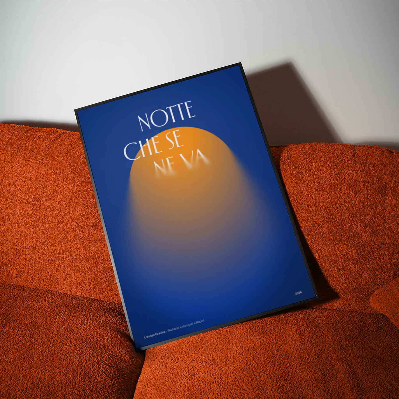 Poster Notte che se ne va incorniciato su divano bouclé arancione — vicolo buio illuminato dal lampione, Posteria Verace